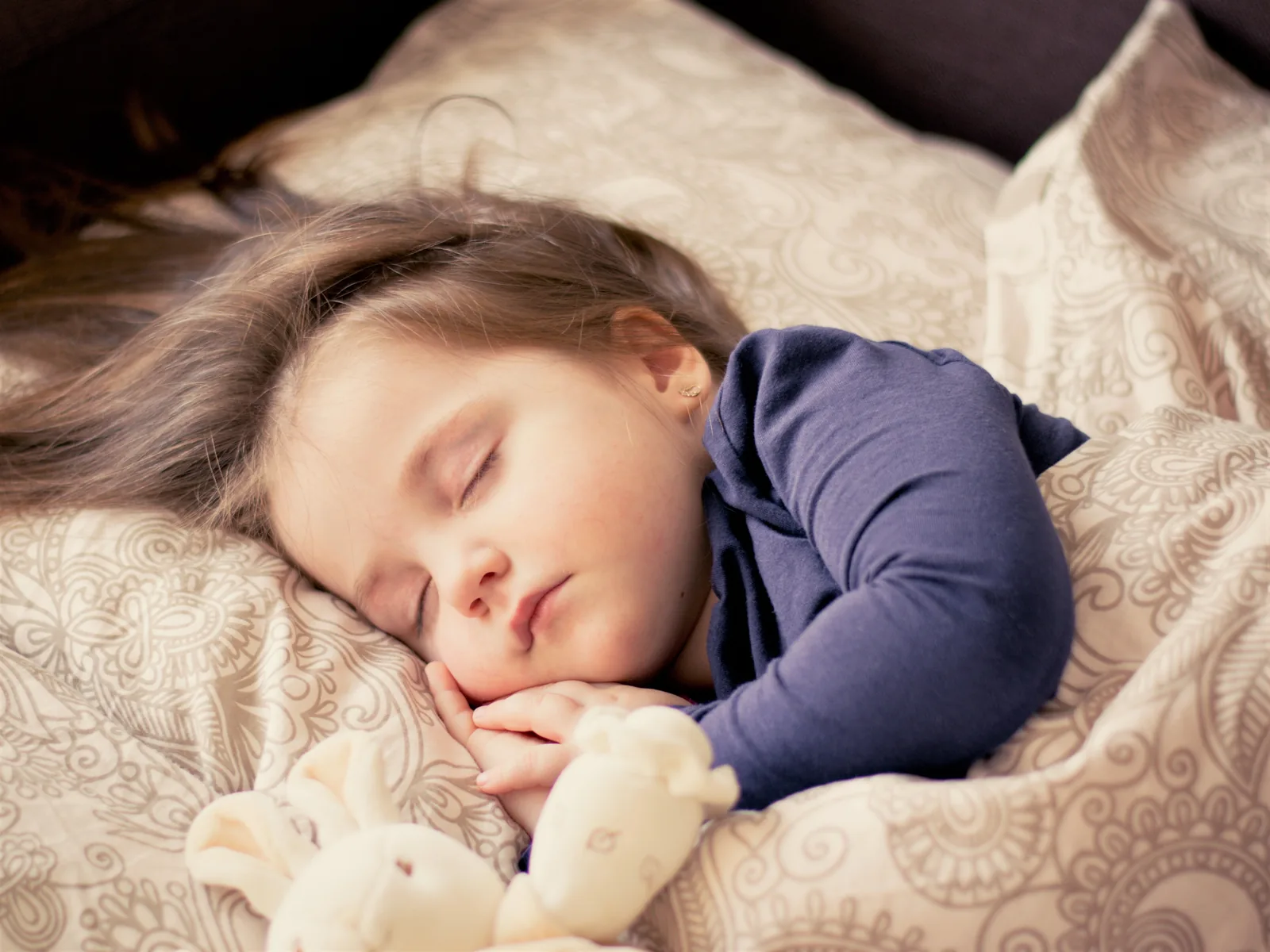 A child asleep and at peace, the nightly work of rest underway
