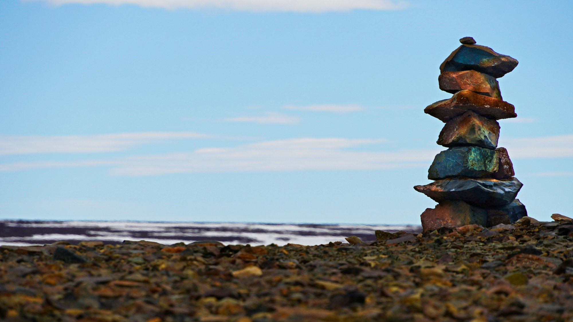 Inuit inuksuk stone cairn against Arctic sky – a guide for travellers between worlds