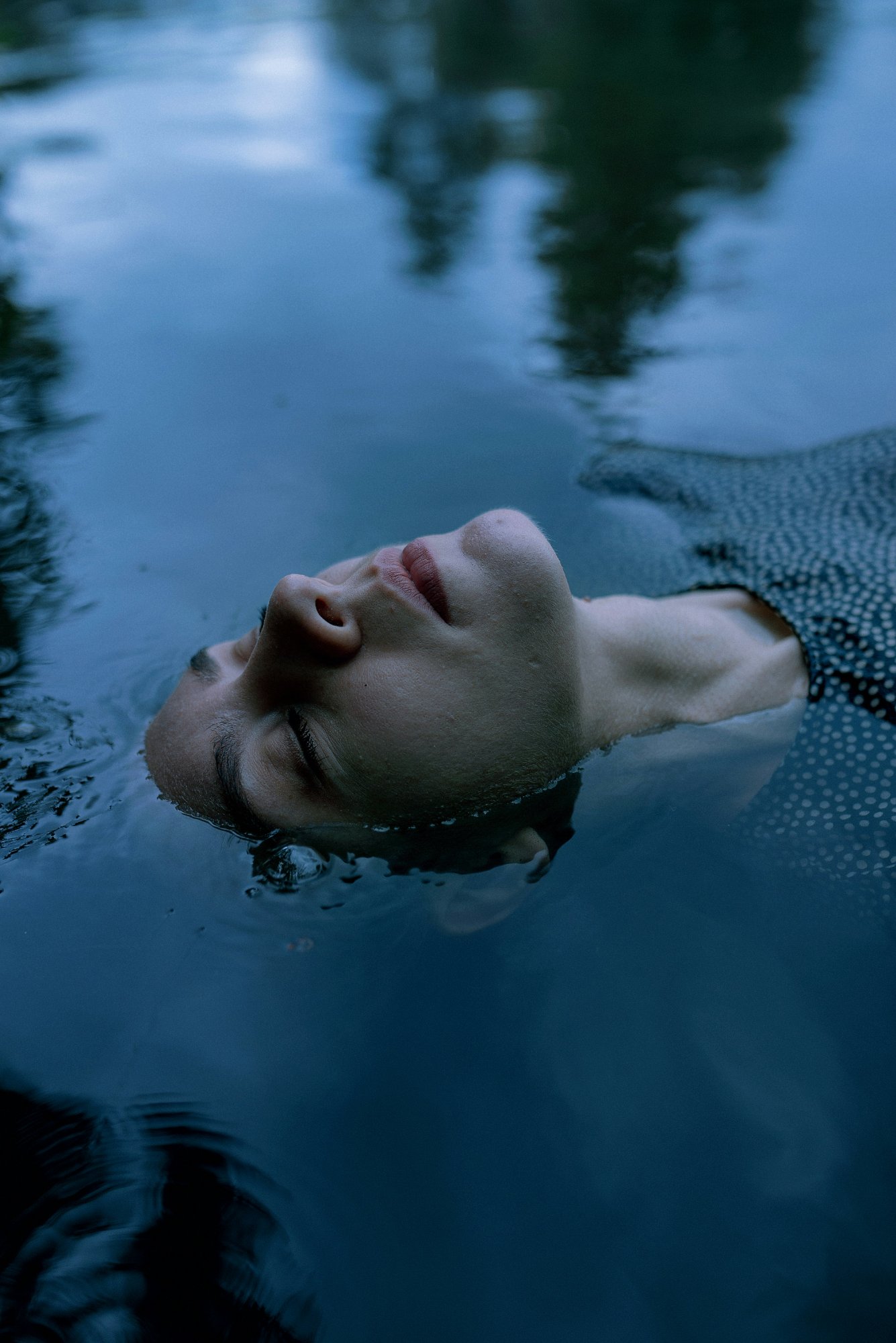 Person floating in still water – the threshold between waking and dreaming